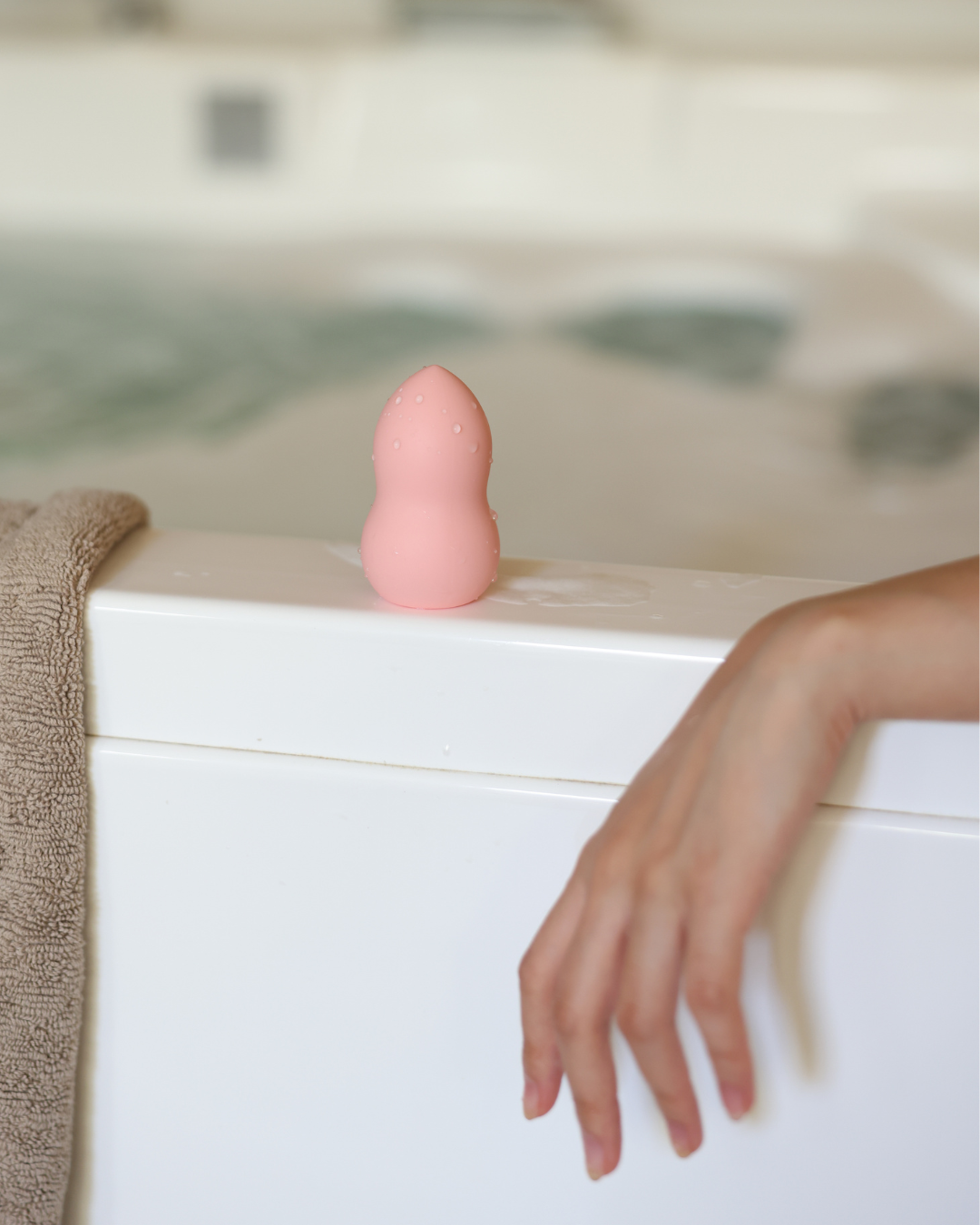 Pink rubber duck on a bathtub with a blurred background